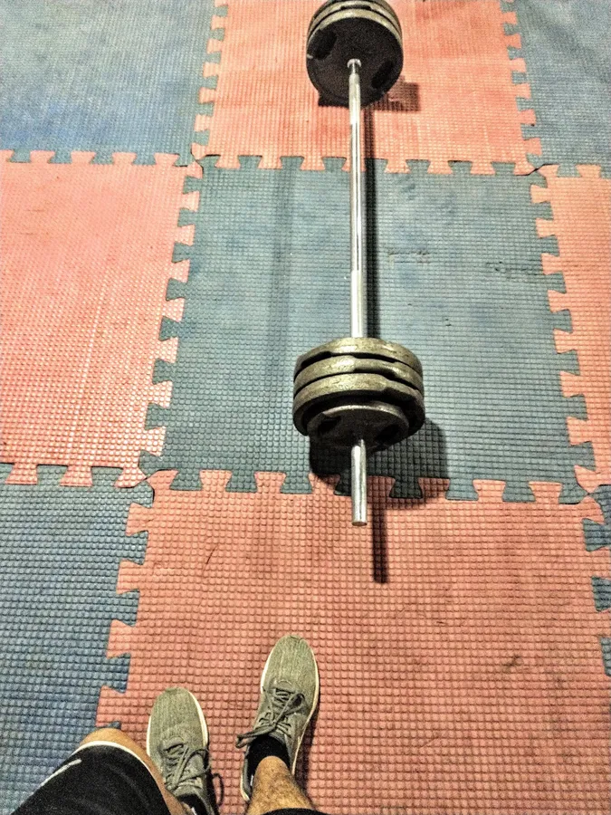 Barra con discos sobre el piso de goma