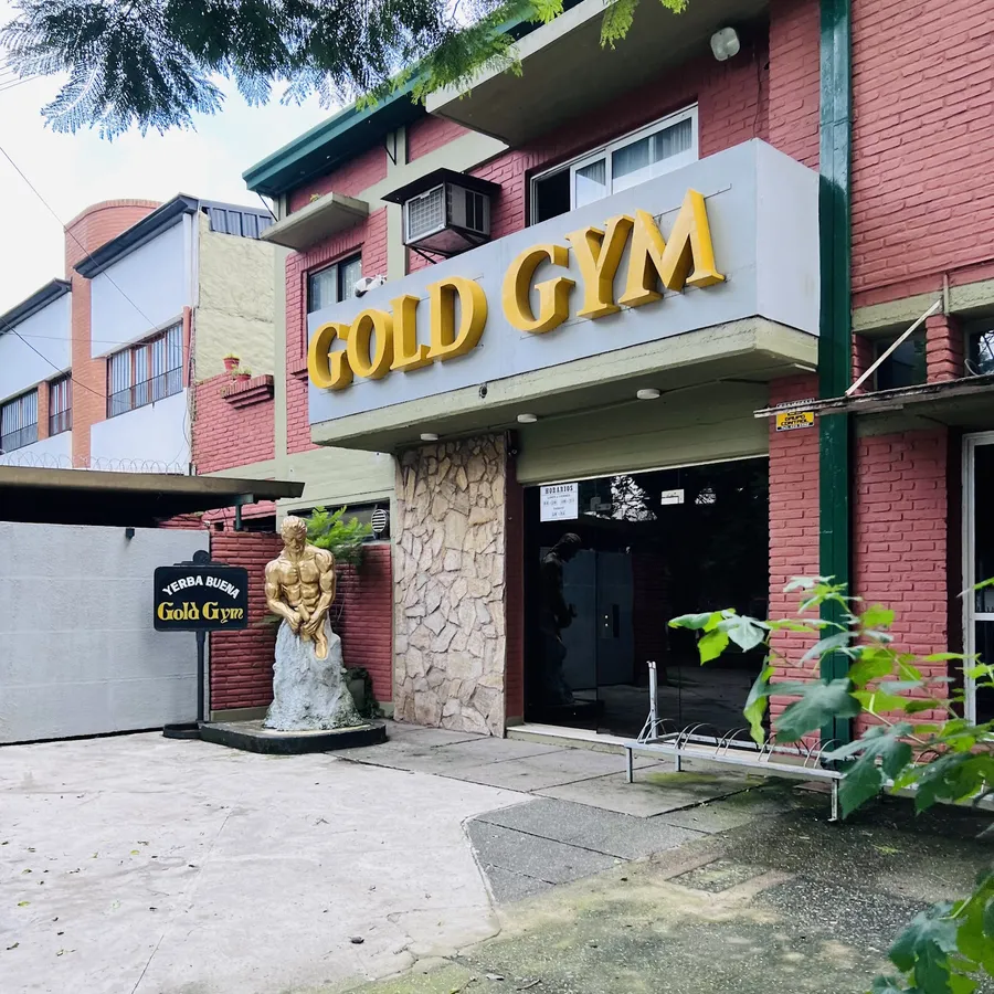 Frente de ladrillo con el cartel dorado de Gold Gym